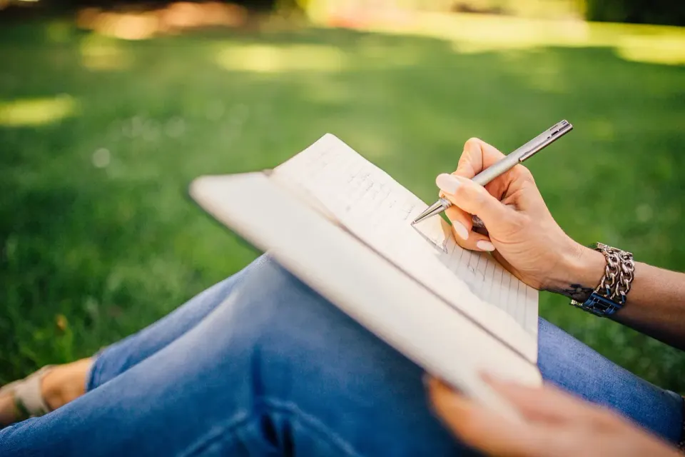 A notebook and pen with handwritten notes, the kind of writing people ask chatbots to critique
