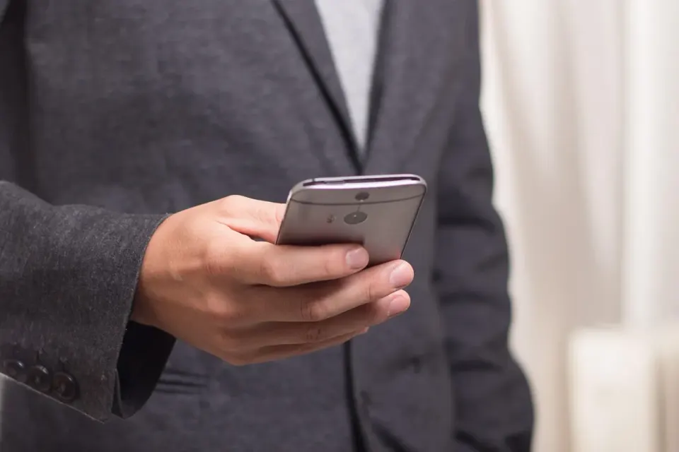 A hand holding a smartphone with a messaging app open, the kind of long conversation the study examined
