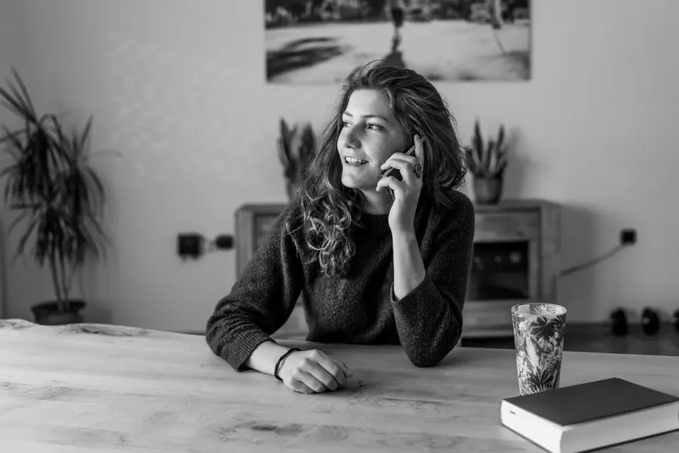 A person holding a smartphone to make a call, a reminder to call back on a number you already trust