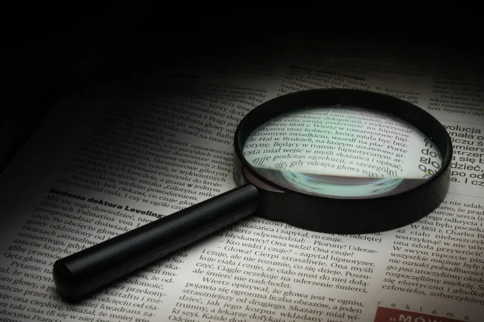 A magnifying glass over printed text, a reminder to check every citation at the source