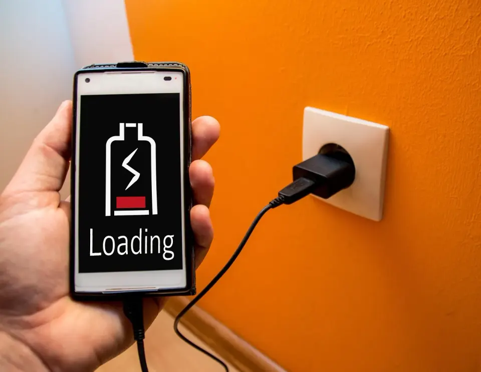 A smartphone showing a loading battery icon, a sign that charging and background tasks are under way